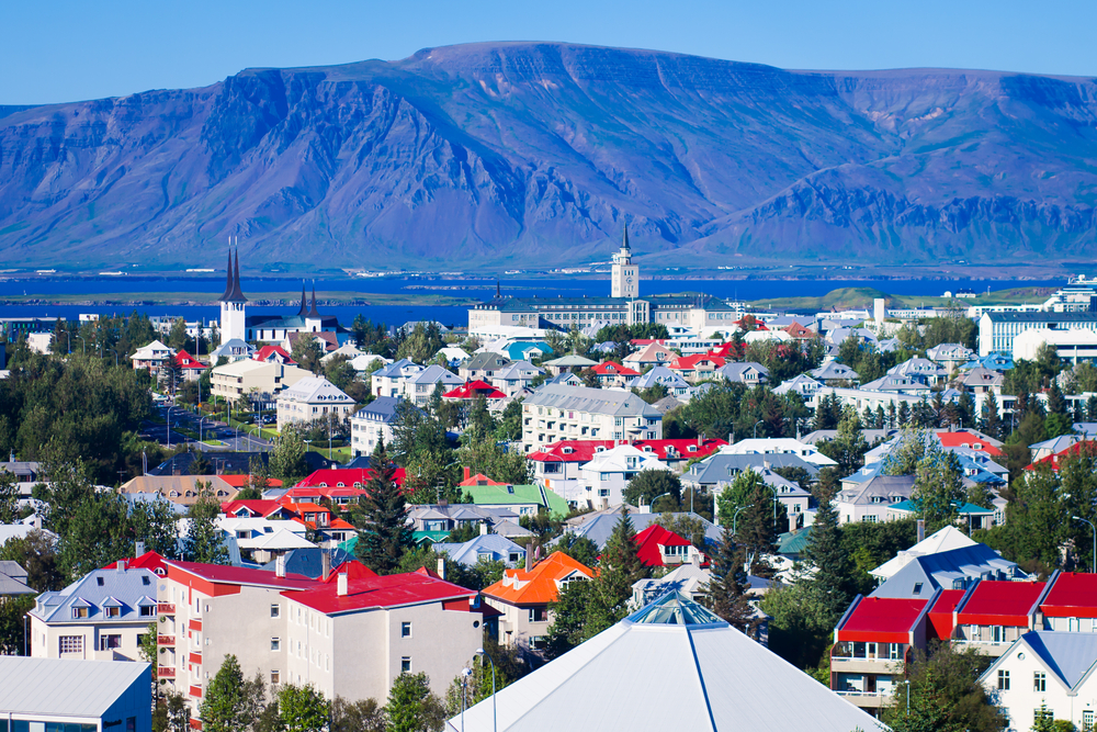 red roofs on colorful homes and buildings near mountains in iceland